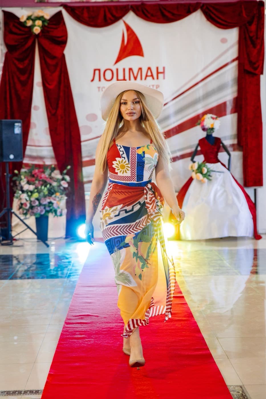 Модель в яркой шляпе на красной дорожке — показ BEZ.MODELS в ТЦ «Лоцман»